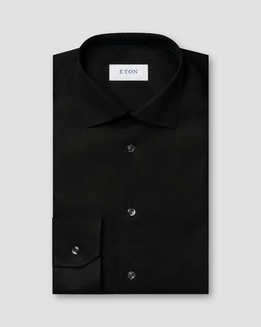 Svart herrskjorta i twill, klassisk modell med knappar och krage, vikt på ljus bakgrund.
