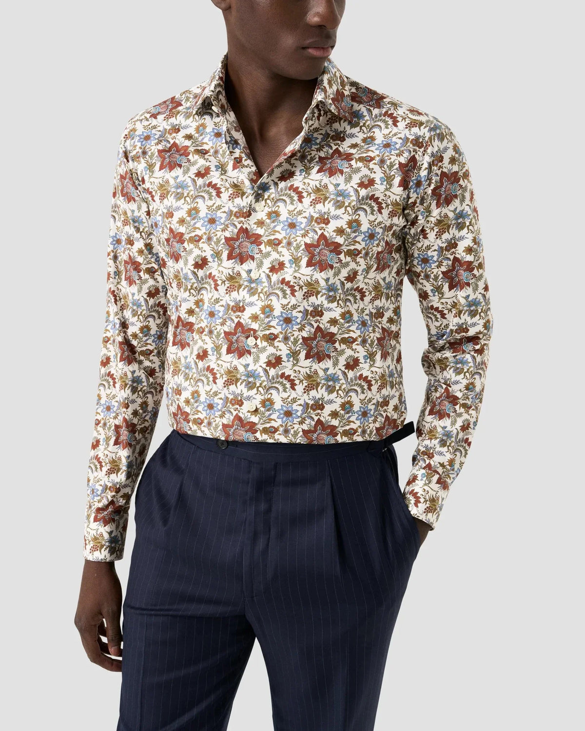 Herrskjorta med blommigt mönster i twill, lång ärm, kombinerad med mörkblå kostymbyxor.