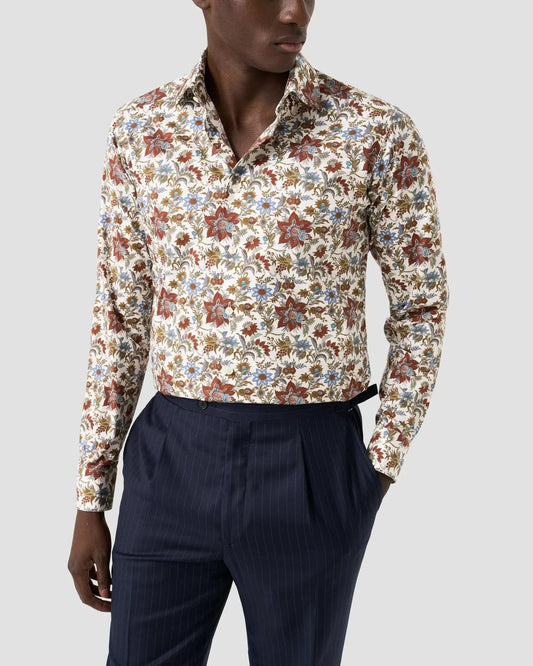 Herrskjorta med blommigt mönster i twill, lång ärm, kombinerad med mörkblå kostymbyxor.