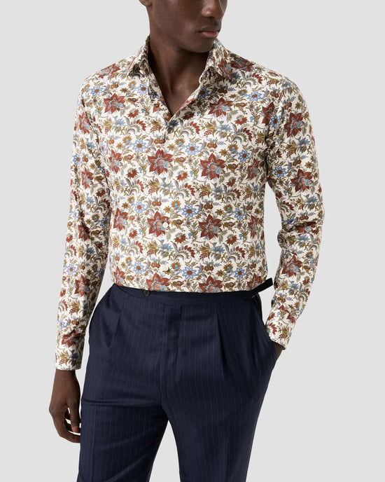 Herrskjorta med blommigt mönster i twill, lång ärm, kombinerad med mörkblå kostymbyxor.