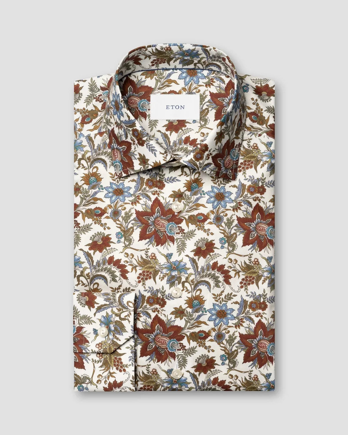 Herrskjorta i vit bomull med röda och blått blommigt mönster, knappar framtill.