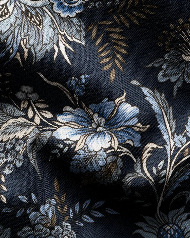 Närbild av marinblå herrskjorta i twill med blommigt mönster i blått och beige.