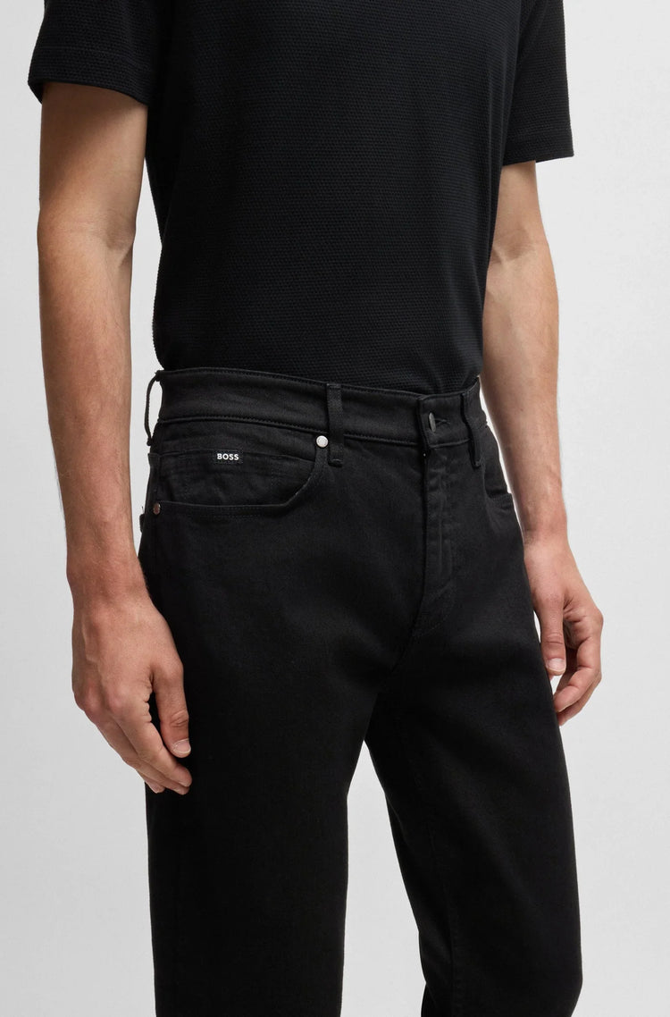 Herr i svart pikétröja och svarta jeans, modern stil, närbild på byxor