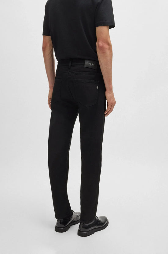Herr i svarta jeans och svart pikétröja, bakifrån, stilren och klassisk herrmode