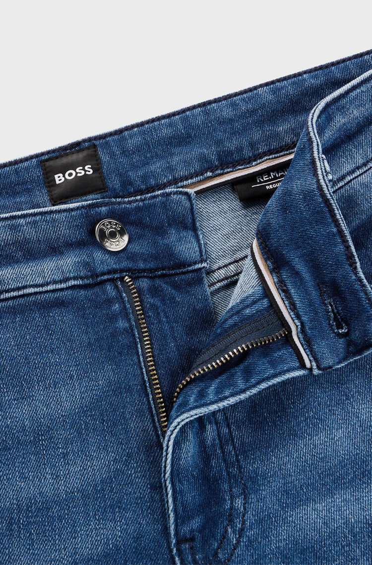 Närbild på blå herrjeans med dragkedja och synlig knapp, klassiska herrkläder.