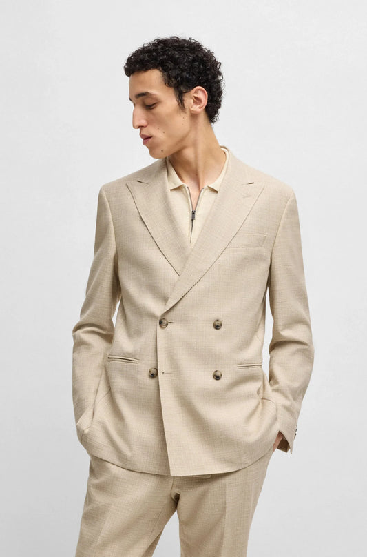 Man i beige dubbelknäppt kostym med krispig skjorta, modern herrmode mot ljus bakgrund