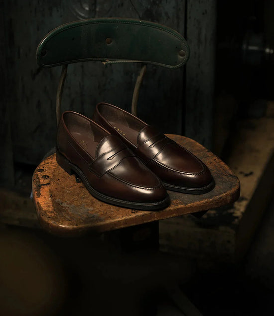 Bruna läderloafers för herr, klassiska herrskor på en vintage stol, elegant stil