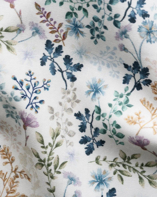 Detalj av ljus twillskjorta med blått blommönster och gröna blad för herr