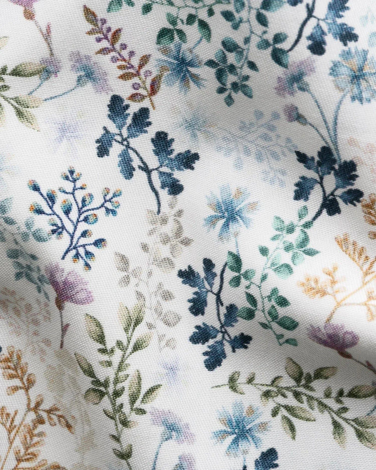 Detalj av ljus twillskjorta med blått blommönster och gröna blad för herr