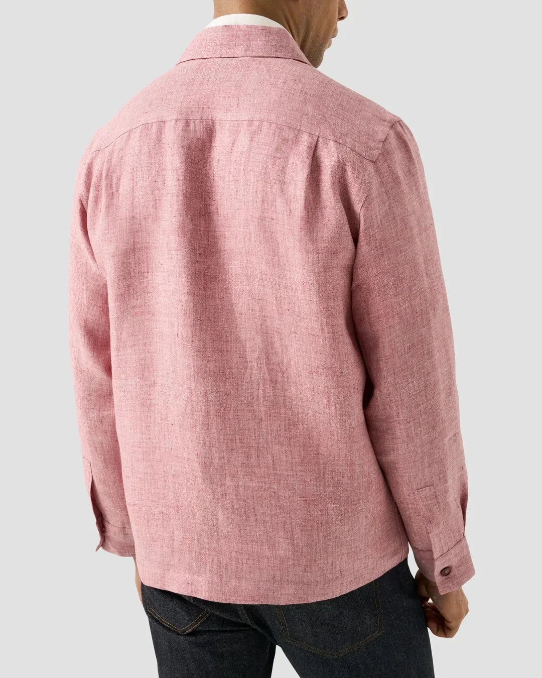 Baksida av rosa linneskjorta för herr, långärmad, stylad med mörka jeans.