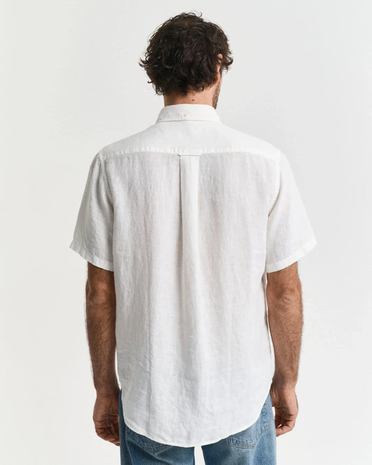 Man i vit linneskjorta och blå jeans, bakifrån mot vit bakgrund