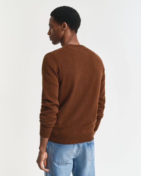 Herr tröja i brunt, långärmad, bärs med blå jeans, bakifrån