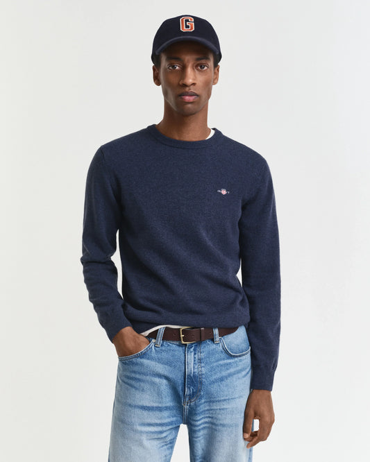 Mörkblå herr tröja med rund hals och jeans, modell bär mörkblå keps.