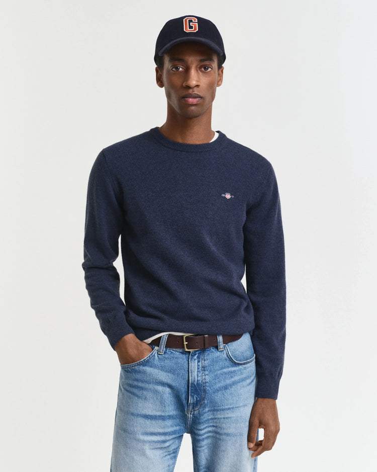 Mörkblå herr tröja med rund hals och jeans, modell bär mörkblå keps.