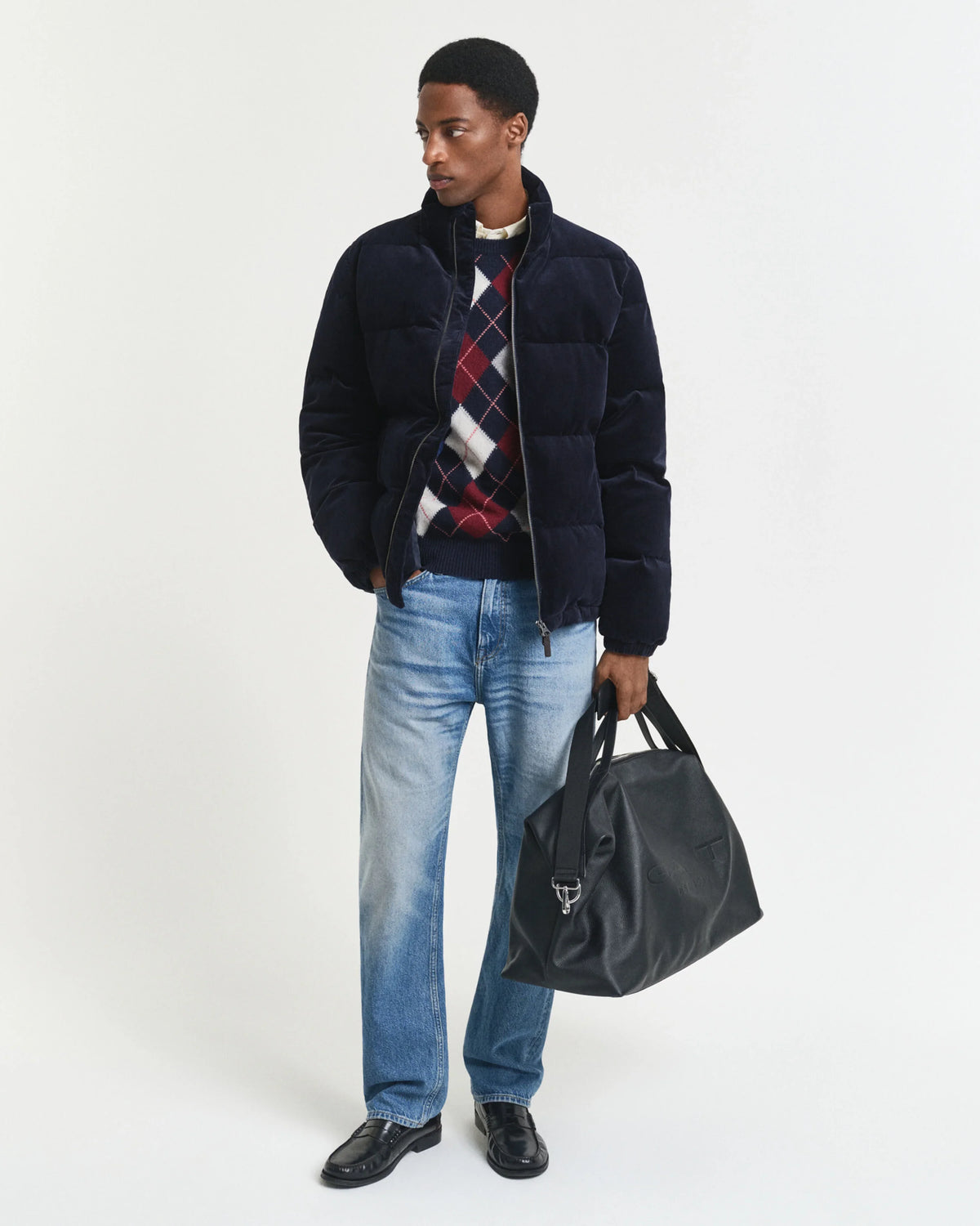 Mörkblå herr vinterjacka med rutor, jeans och svart väska, studiofoto