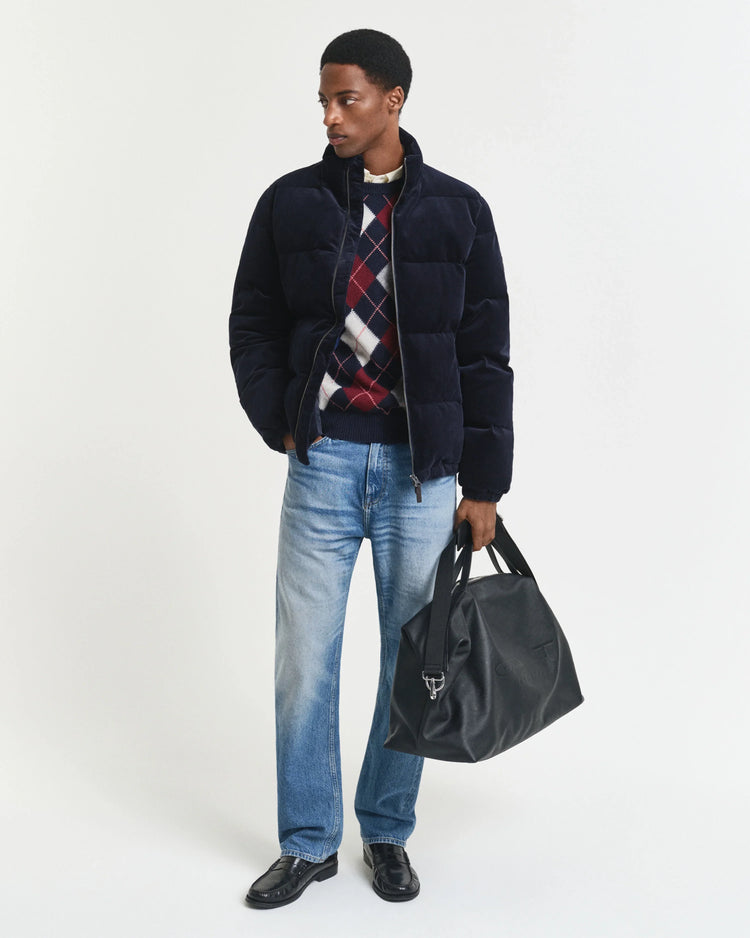 Mörkblå herr vinterjacka med rutor, jeans och svart väska, studiofoto