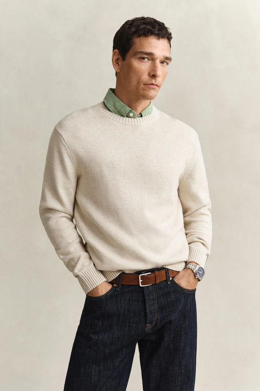Beige stickad herrtröja, grön skjorta och mörkblå jeans