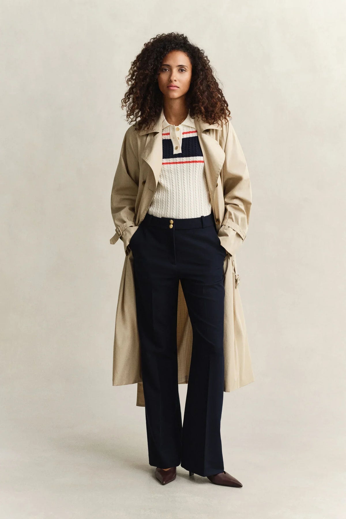 Beige trenchcoat, vit stickad tröja med ränder, marinblå kostymbyxor dam