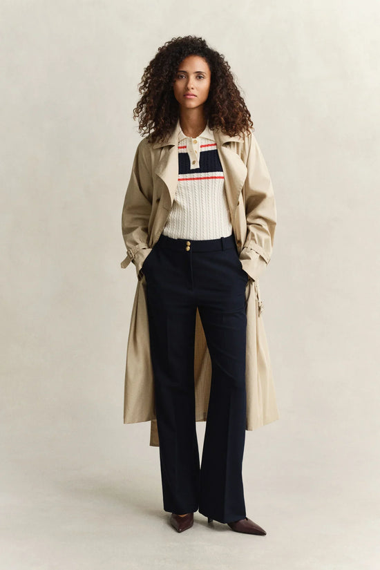 Beige trenchcoat, vit stickad tröja med ränder, marinblå kostymbyxor dam
