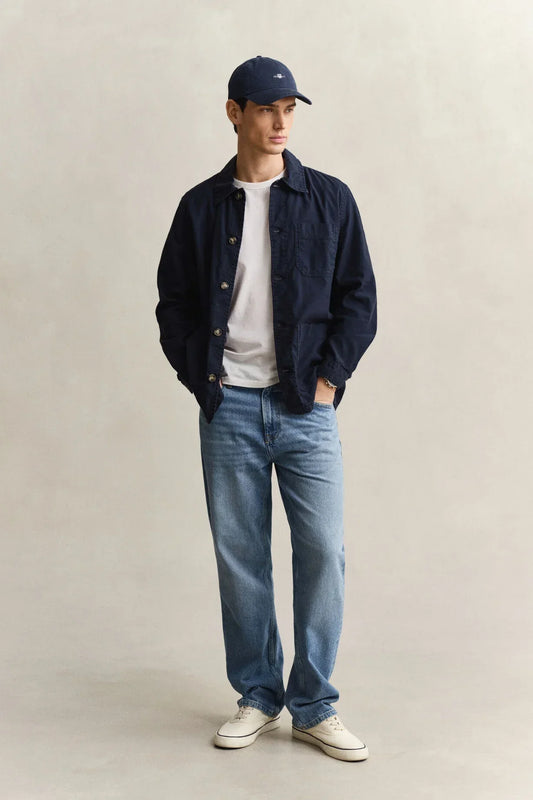 Marinblå skjorta herr, vit t-shirt, ljusblå jeans och marinblå keps