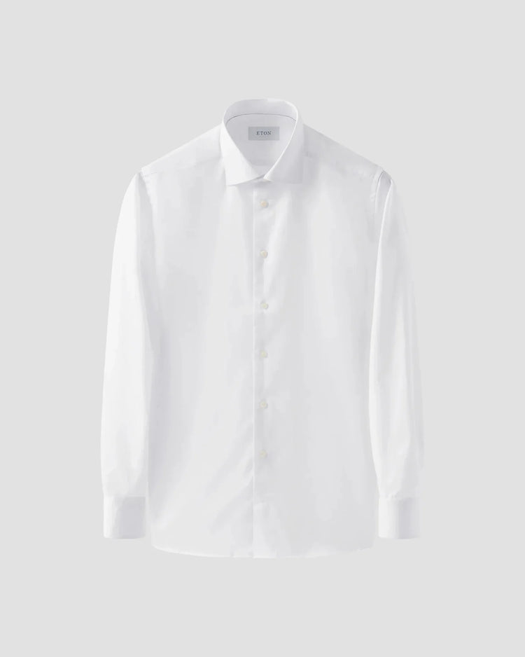 Klassisk vit herrskjorta i twill, långärmad med knappar och krage, mot ljus bakgrund.