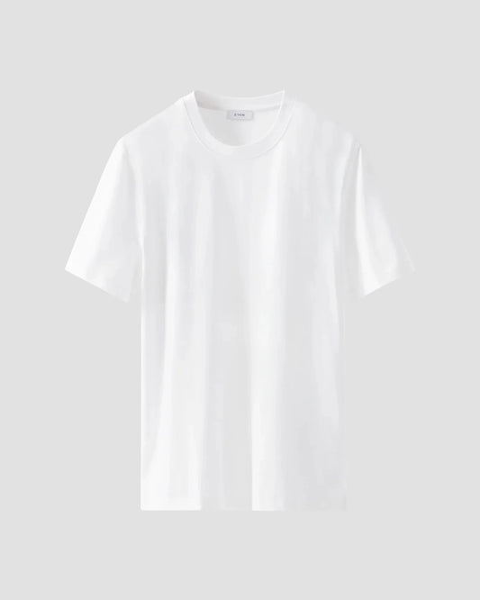 Klassisk vit t-shirt i bomull för herr, kort ärm, rund hals, mot ljus bakgrund.