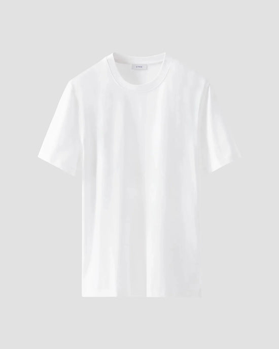 Klassisk vit t-shirt i bomull för herr, kort ärm, rund hals, mot ljus bakgrund.