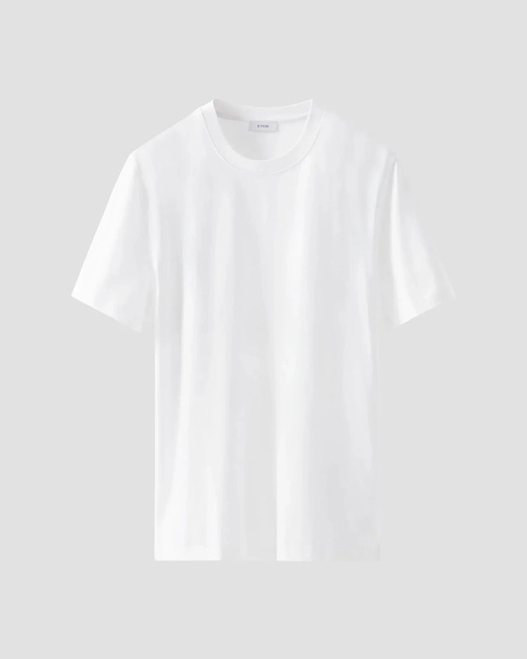 Klassisk vit t-shirt i bomull för herr, kort ärm, rund hals, mot ljus bakgrund.