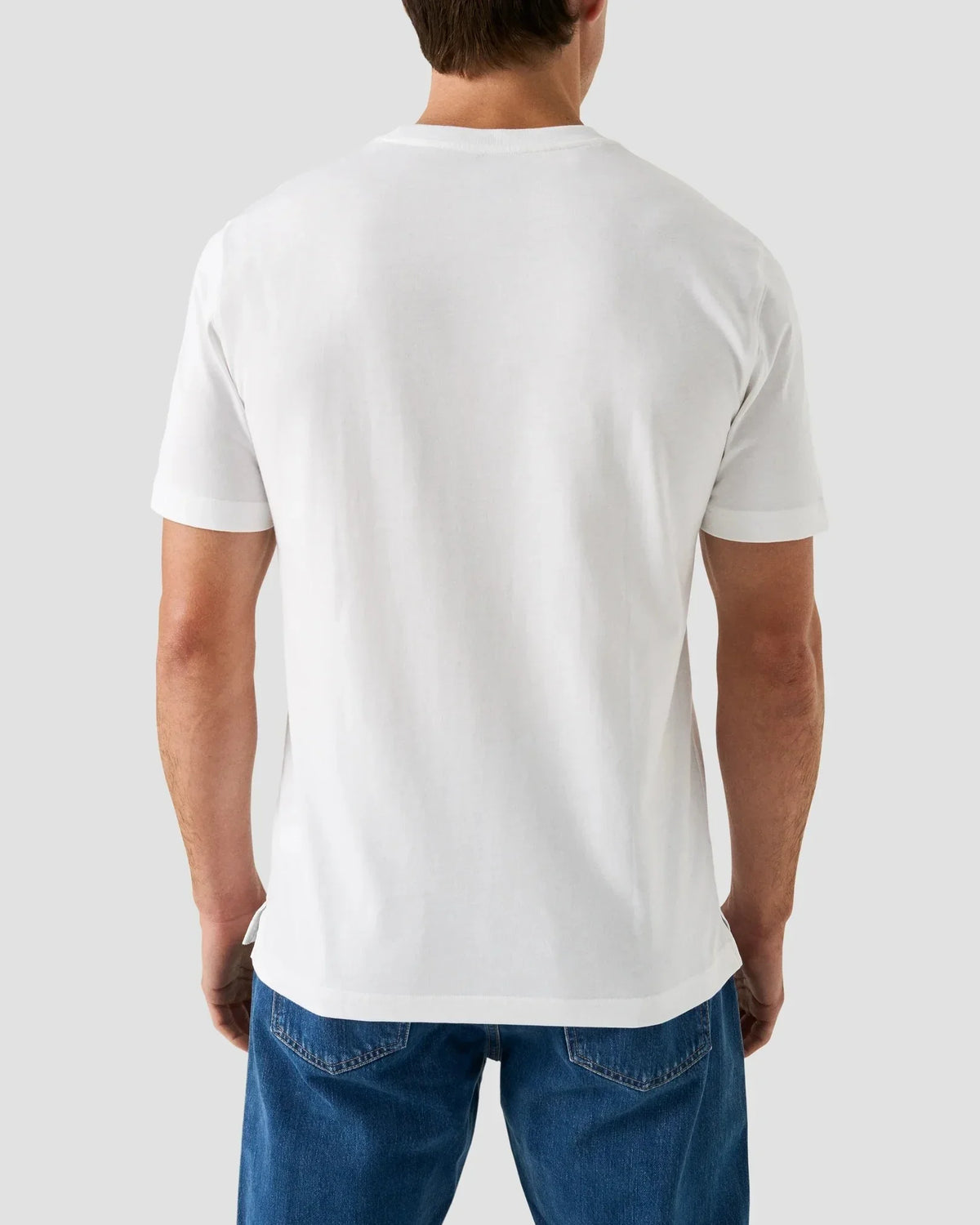 Vit t-shirt herr, baksida, klassisk passform, jeans, enkel stil mot grå bakgrund